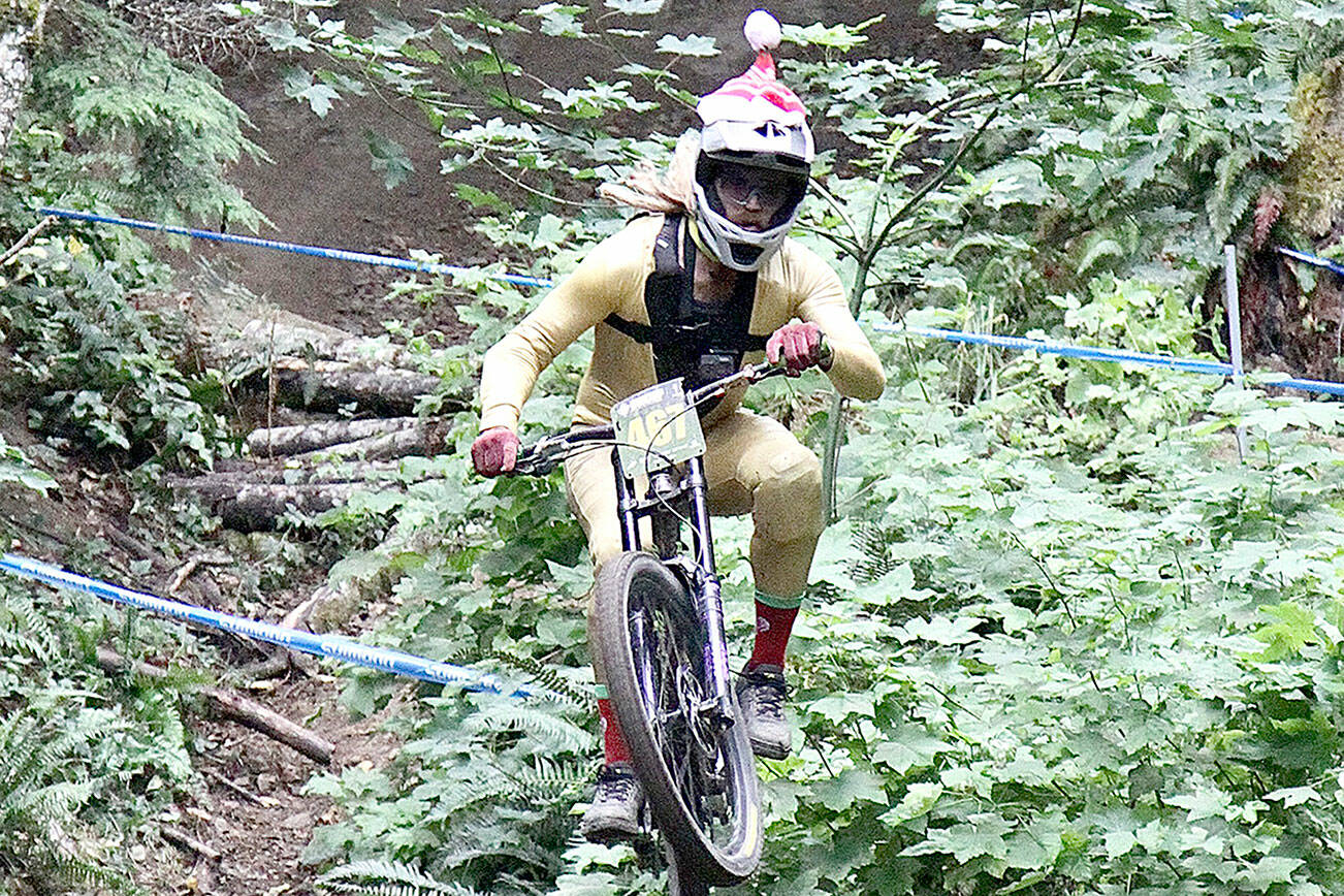 Blake Nelson of Wenatchee, wearing a Santa cap, flies down the course at Dry Hill on Sunday. Nelson finished second in the 30-39 age bracket. (Dave Logan/for Peninsula Daily News)