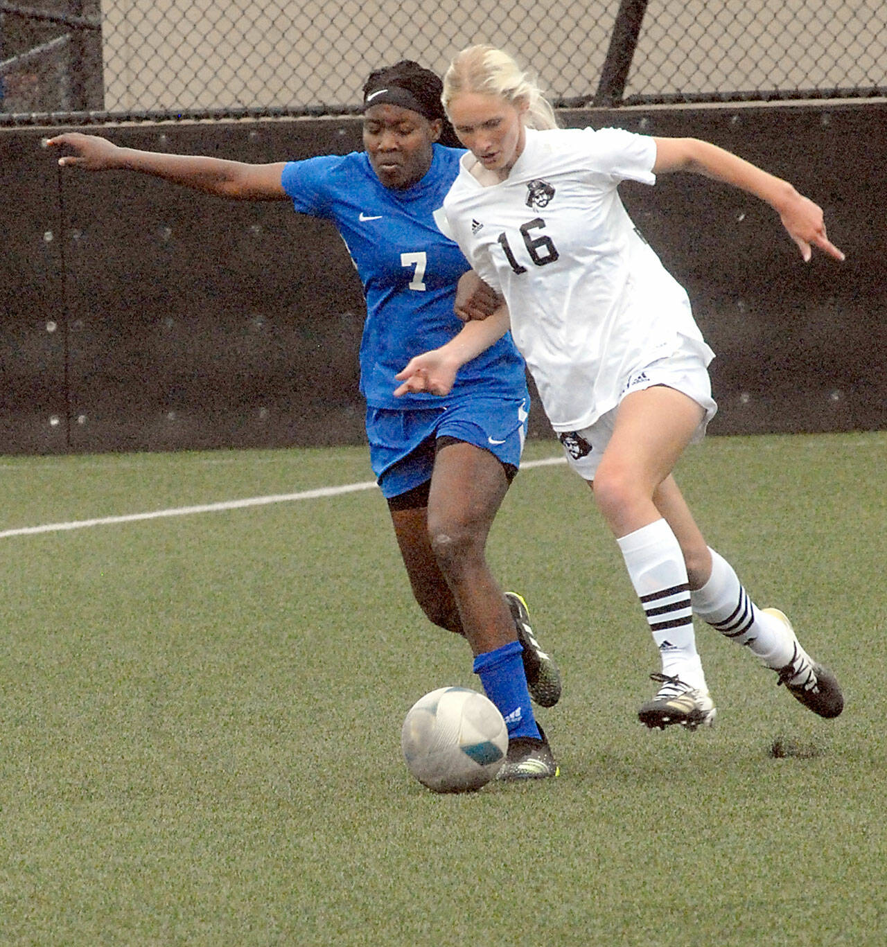 Peninsula’s Millie Long, a graduate of Port Angeles High School, right, tries to outrace Edmonds’ Flero Dina Surpris on Wednesday at Wally Sigmar Field in Port Angeles. (Keith Thorpe/Peninsula Daily News)