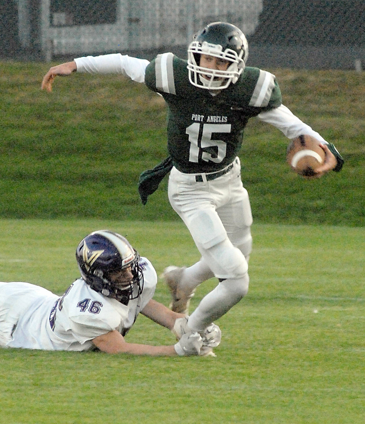 Keith Thorpe/Peninsula Daily News Port Angeles quarterback Parker Nickerson gets tripped up on a short run by North Kitsap’s Benen Lawler on Friday night at Port Angeles Civic Field.