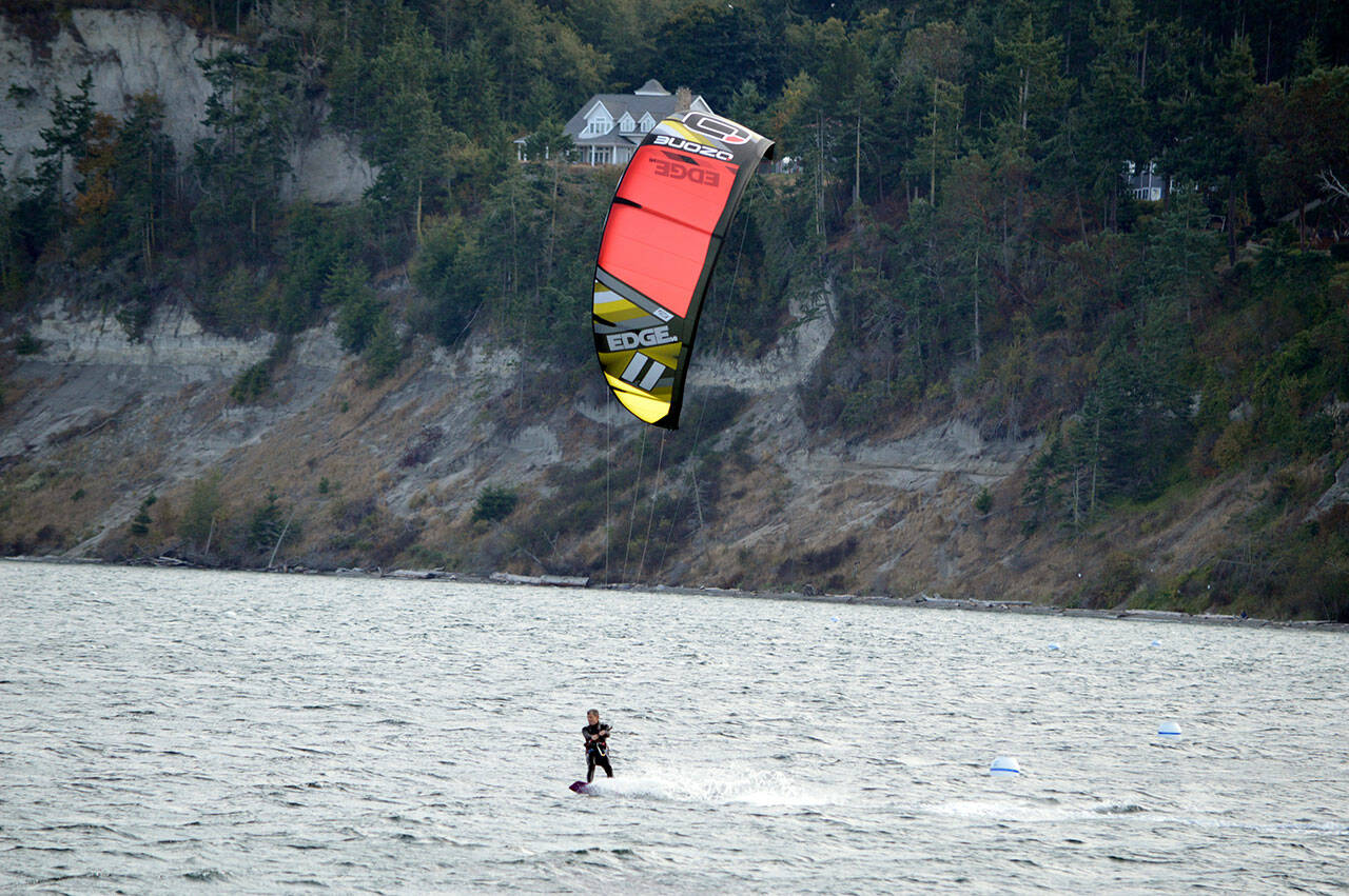In what he called a “good frisky breeze,” Josh Porter of Port Townsend kiteboards across the Salish Sea beside Fort Worden State Park. (Diane Urbani de la Paz/Peninsula Daily News)