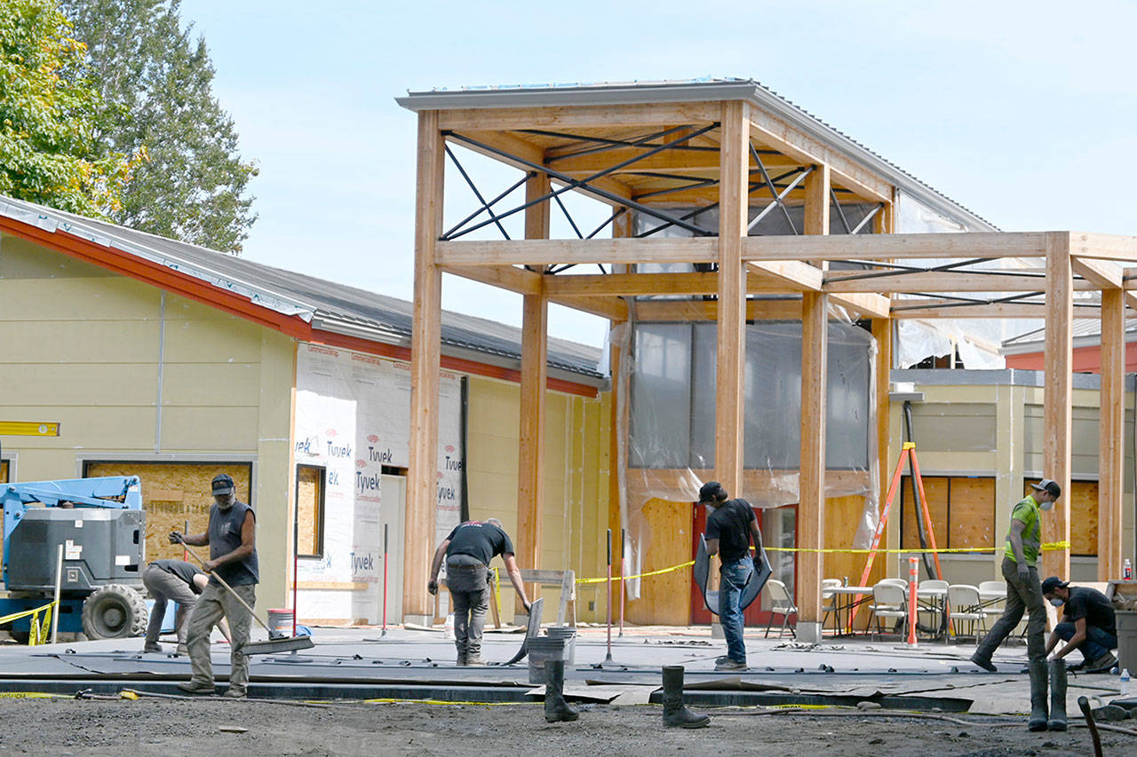 Construction continues at the newly renamed Dungeness River Nature Center in late August. Workers with Hiday Concrete, Inc., work on the patio that will more than double the original outdoor entrance space, river center officials said. The center, undergoing a multi-million-dollar expansion, is expected to reopen this fall. (Michael Dashiell/Olympic Peninsula News Group)
