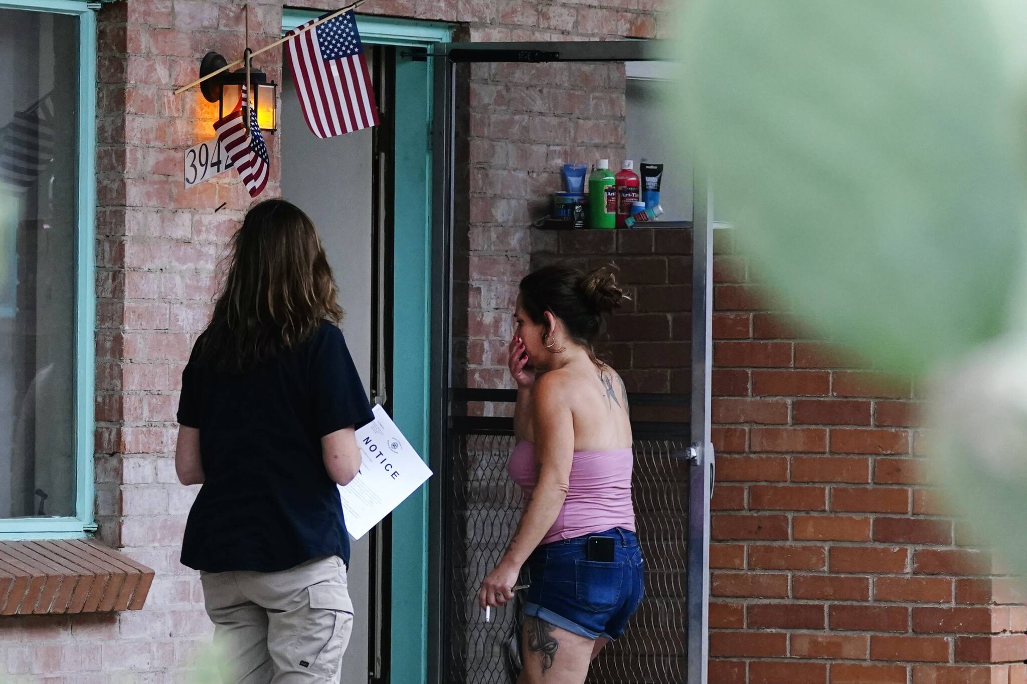 Pima County Constable Kristen Randall, left, speaks to a rental resident letting them know about their eviction notice  Sept. 24 in Tucson, Ariz.  (AP Photo/Ross D. Franklin)
