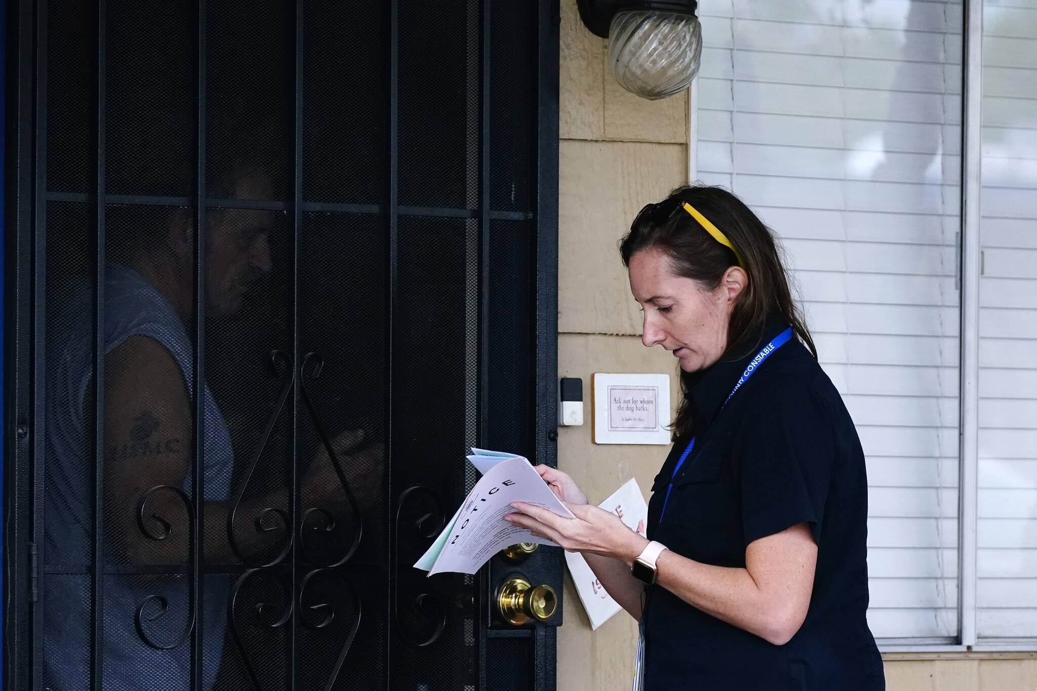 Pima County Constable Kristen Randall, right, speaks to rental resident Paul Wunder, left, letting him know about his eviction notice and explaining to him the options he has for community programs Sept. 24 in Tucson, Ariz. (AP Photo/Ross D. Franklin)