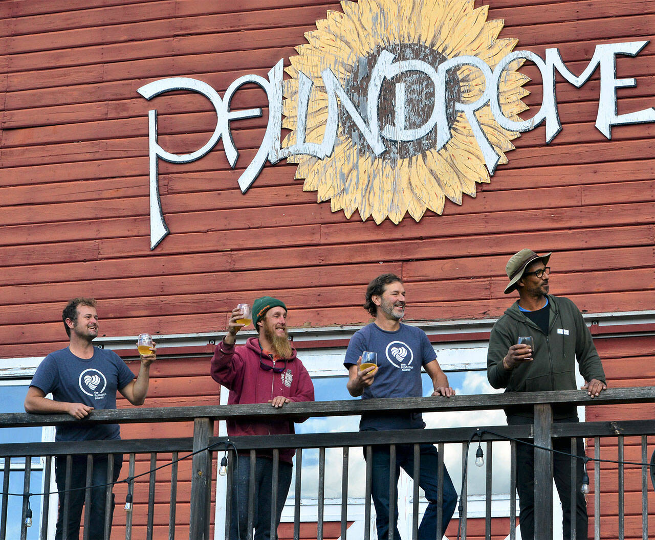 Taking a break from setting up for the Olympic Peninsula Apple & Cider Festival, four Production Alliance crew members — from left, Danny Milholland, Shane Parish, Larry Lawrence and Damon Barlow — look out over the orchard at Eaglemount Winery-Cidery of Port Townsend. (Diane Urbani de la Paz/Peninsula Daily News)