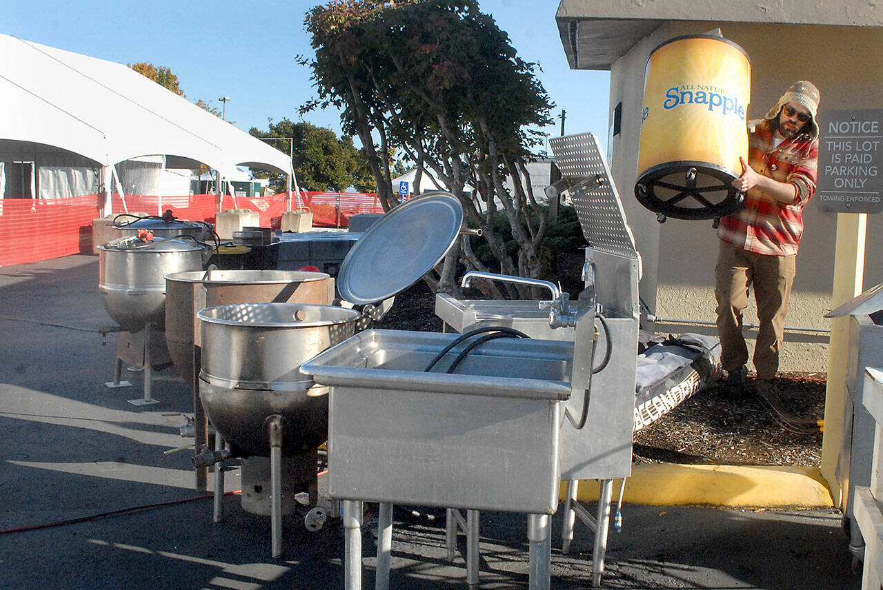 Quinton Chastain of Olympia carries an insulated barrel on Thursday while setting up an outdoor kitchen for this weekend’s Dungeness Crab and Seafood Festival near the Port Angeles waterfront. (Keith Thorpe/Peninsula Daily News)