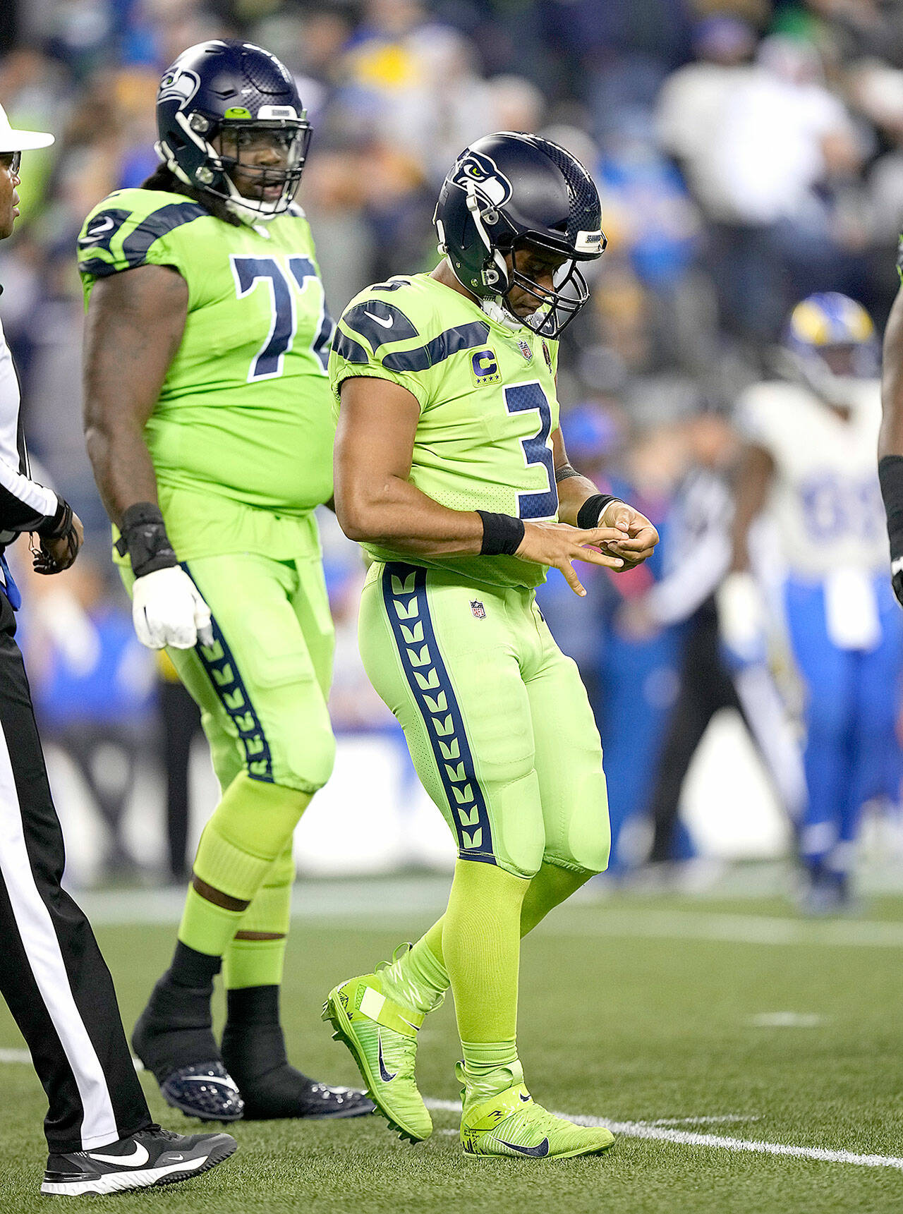 Seattle Seahawks quarterback Russell Wilson (3) leaves the field with an injured fingers Thursday night against the Los Angeles Rams in Seattle. The Los Angeles Rams won 26-17. (AP Photo/Ben VanHouten)