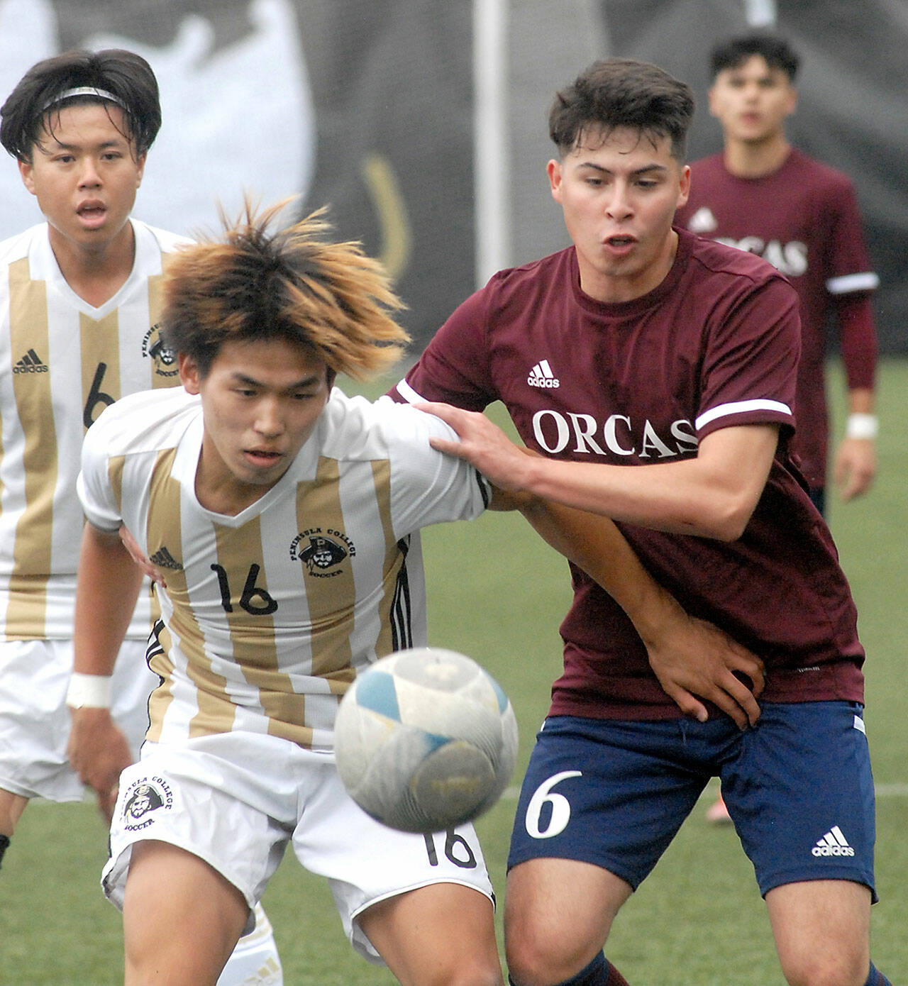 Peninsula’s Hayahide Sakamoto, front left, and Whatcom’s Juan Obeso eye a loose ball on Saturday at Peninsula College. Behind Sakamoto is teammate Jeong Hyun Kang. (Keith Thorpe/Peninsula Daily News)