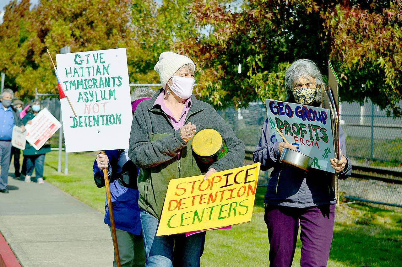 Katie Franco, center, and Libby Palmer of Port Townsend demonstrate support for Haitian asylum seekers outside the Tacoma Northwest Detention Center on Sunday. (Diane Urbani de la Paz/Peninsula Daily News)
