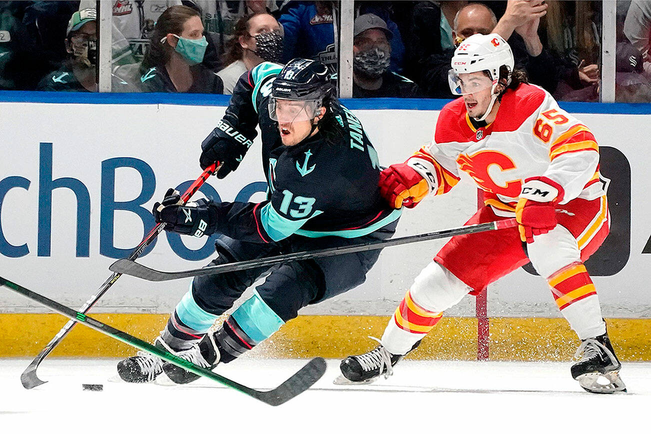 Seattle Kraken left wing Brandon Tanev (13) drives around Calgary Flames right wing Ryan Francis (65) during the first period of an NHL preseason hockey game, Saturday, Oct. 2, 2021, in Kent, Wash.. (AP Photo/Ted S. Warren)