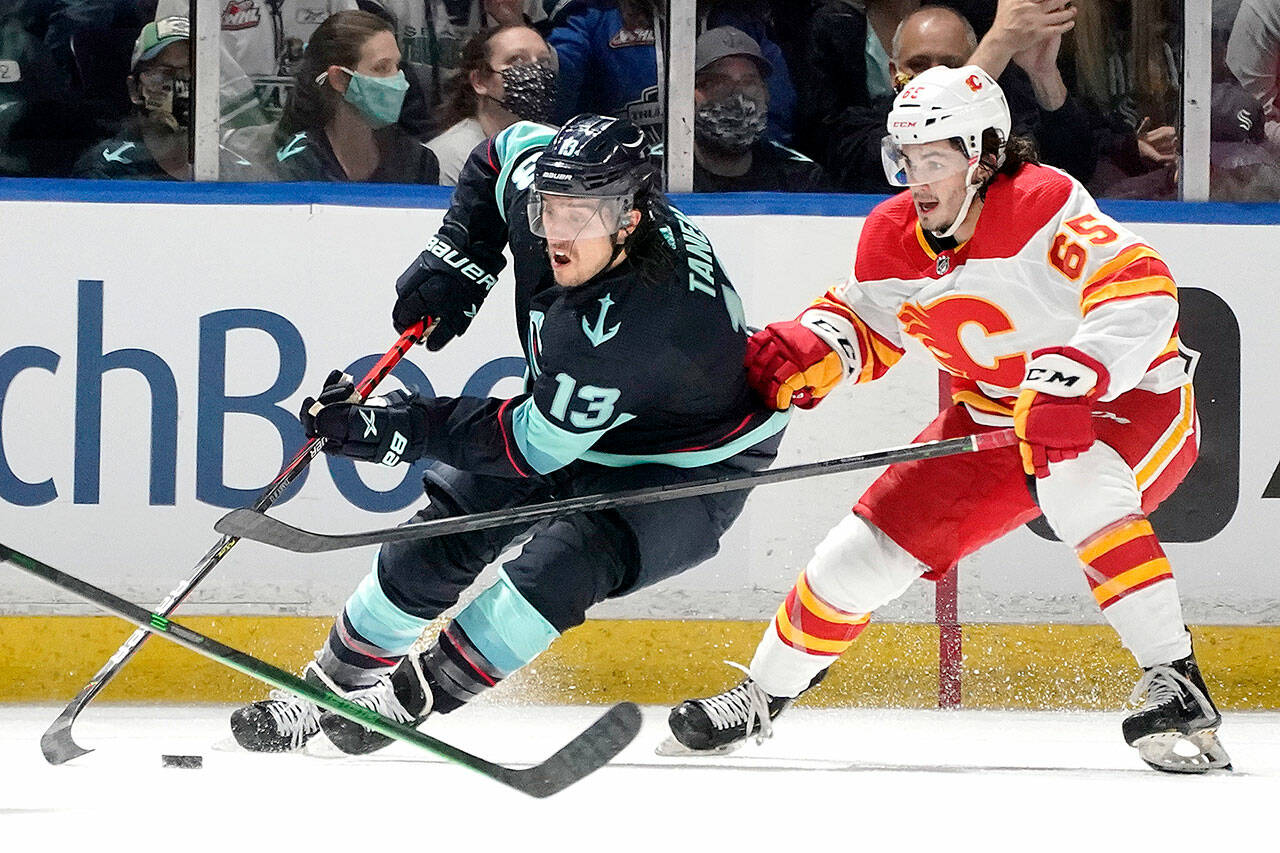 Seattle Kraken left wing Brandon Tanev (13) drives around Calgary Flames right wing Ryan Francis (65) during the first period of an NHL preseason hockey game on Oct. 2, 2021, in Kent. (Ted S. Warren/The Associated Press)