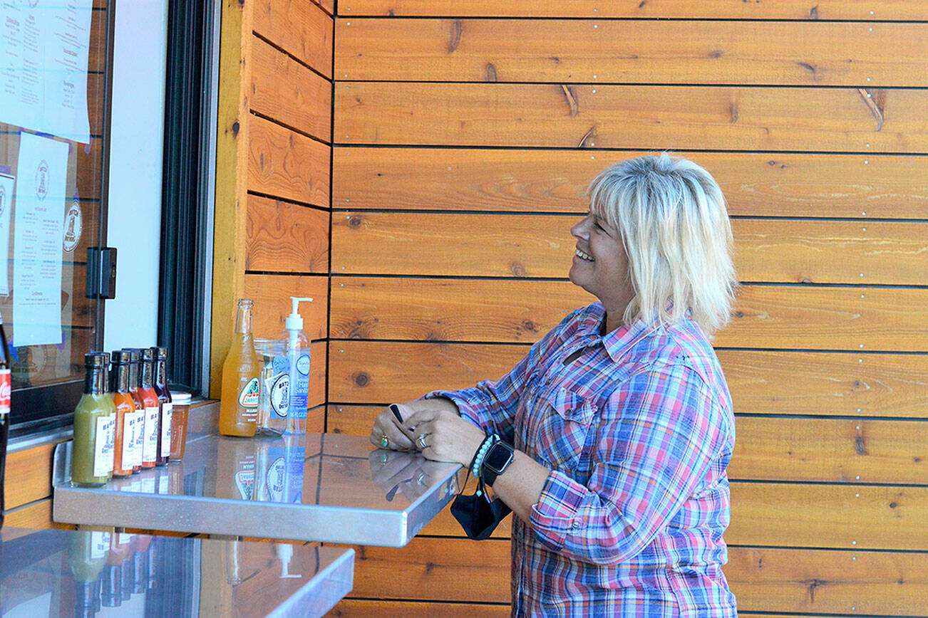 Lila's Kitchen owner Wendy Davis stops by the Batch Brothers window on a recent afternoon. Diane Urbani de la Paz/Peninsula Daily News.