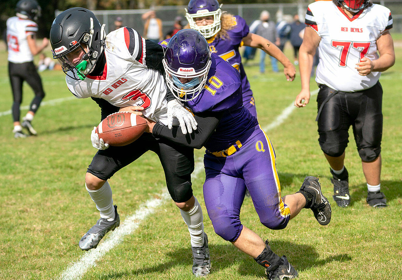 Neah Bay’s Neil Bowechop is tackled by Quilcene’s James Miller (10) as the Rangers’ Jeremy Allen (15) and Neah Bay’s Azriel Swan-Jimmicum (77) are in on the play. (Steven Mullensky/for Peninsula Daily News)