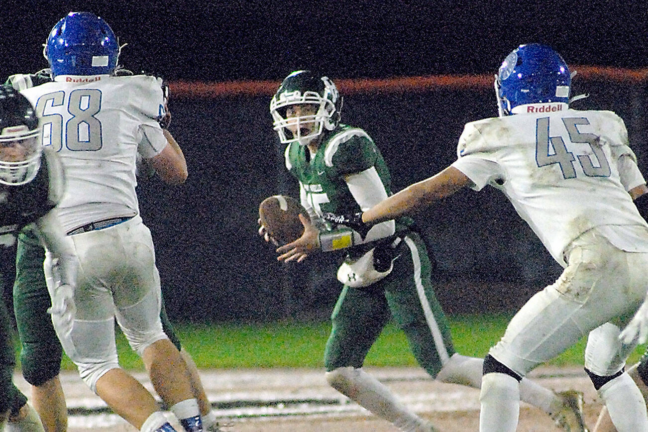 Keith Thorpe/Peninsula Daily News
Port Angeles quarterback Parker Nickerson, center, looks downfield as Olympic's Jacob Gesell, left, and Alexander Larson, right, close in on Friday night at Port Angeles Civic Field.