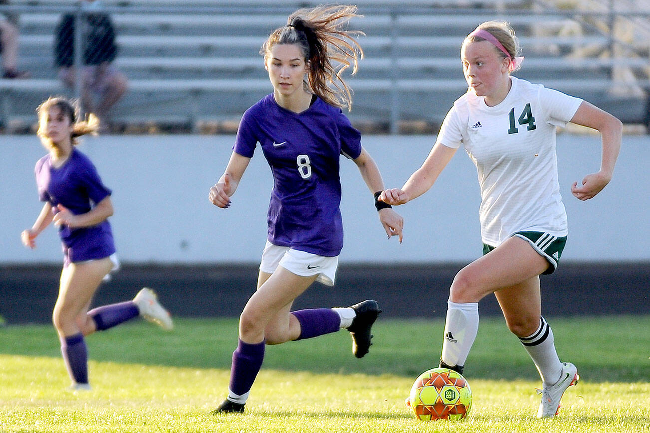 Michael Dashiell/Olympic Peninsula News Group
Port Angeles' Anna Petty (14) looks upfield as she dribbles against Sequim's Zoe Moore. Petty, the Roughriders' lockdown defensive central midfielder, is the All-Peninsula Girls Soccer MVP