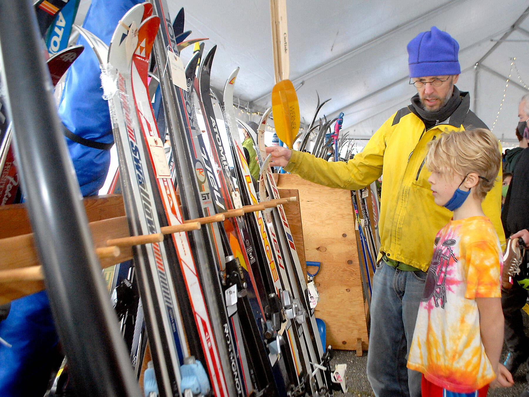 Ned Hammar of Port Angeles and his son, Felix Lubinski Hammar, 9, examine a rack of snow skies during Saturday’s Winterfest ski swap in the Black Ball Ferry parking lot on the Port Angeles waterfront. The event, a fundraiser for the Hurricane Ridge Winter Sports Club, featured a variety of skis, snowboards and related sports gear. No total from the event was available on Sunday. (Keith Thorpe/Peninsula Daily News)