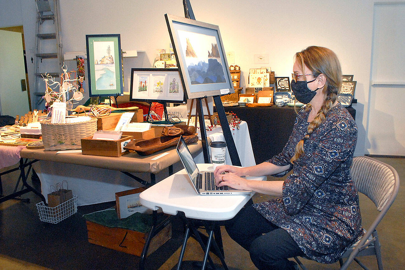 Port Angeles artist Sarah Tucker takes an inventory of items made by area artisans that will be available for sale at the Wintertide Makers Market at the Port Angeles Fine Arts Center. (Keith Thorpe/Peninsula Daily News)