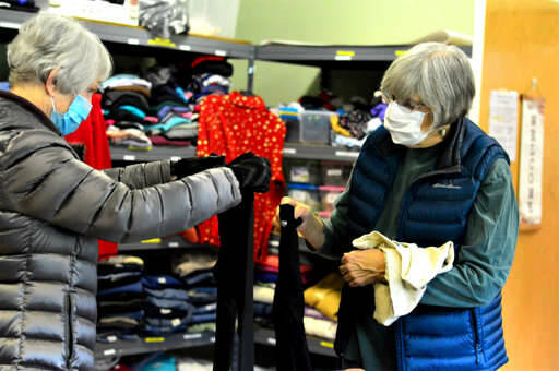 Volunteers A.J. Laverty, left, and Marsha Hamacher organize the winter outfits at the Community United Methodist Church’s clothing room. The room is open for free shopping on Saturdays. (Diane Urbani de la Paz/Peninsula Daily News)