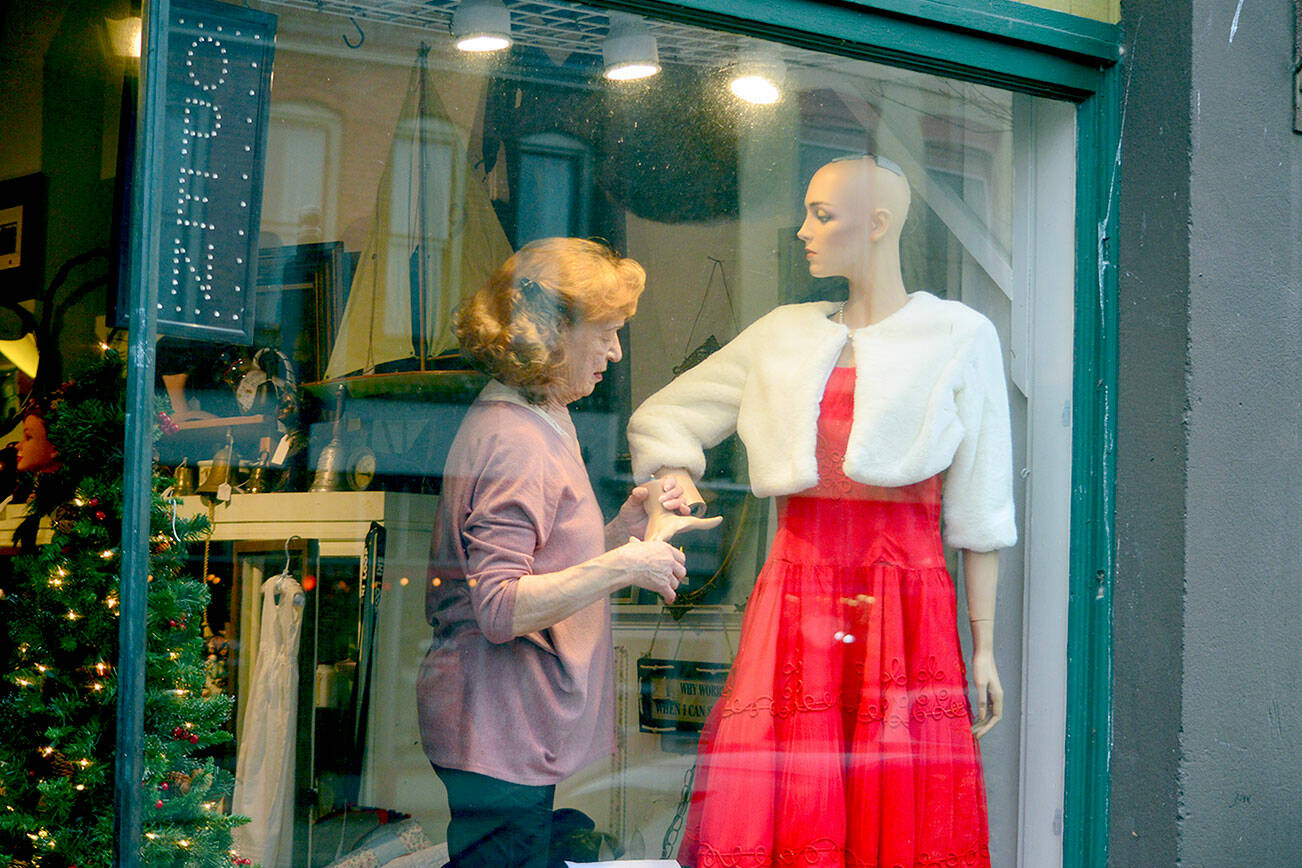 Marion Castaneda prepares a mannequin at her Deja Vu store on Water Street in Port Townsend, where the Main Street Program is organizing a variety of activities this month, including the Winter Window Wander of decorated shop windows downtown and the community Christmas tree lighting at dusk Saturday. Under and near the Tyler Street Plaza tent at Tyler and Water streets Saturday afternoon, the Wild Rose Chorale will sing, Santa will pose for photos and the Kiwanis Choo Choo train will come by. Details are found at the Port Townsend Main Street website. (Diane Urbani de la Paz/Peninsula Daily News)