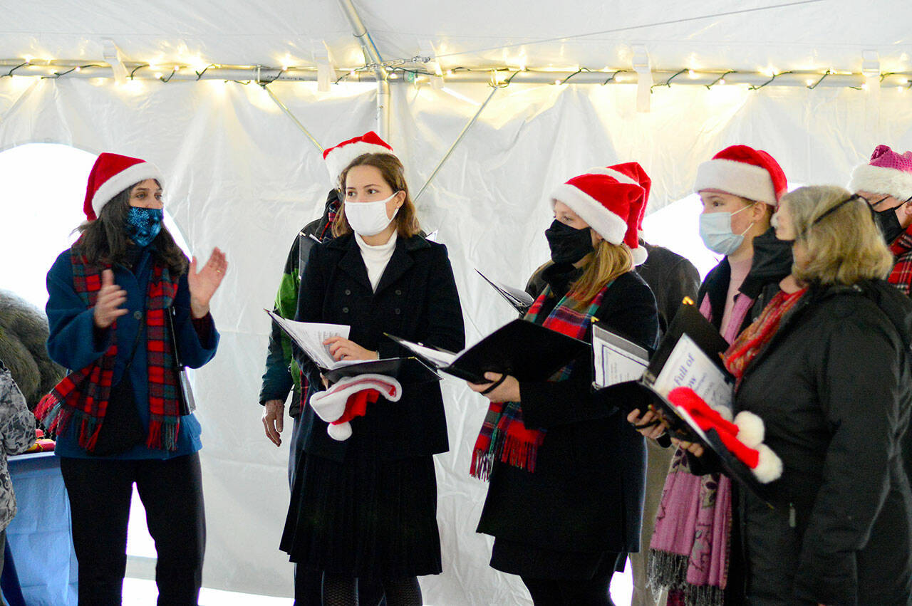 Members of the Wild Rose Chorale sang a cappella holiday songs at various spots in downtown Port Townsend on Saturday afternoon. Their music was hosted by the Main Street Program, which also organized the community Christmas tree and Uptown fire tower lighting later that afternoon. (Diane Urbani de la Paz/Peninsula Daily News)