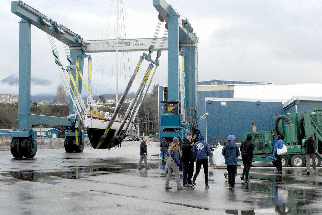 Members of the Marvin Shields Ship 1212 of the Sea Scouts watch as the sailboat Aurora is carried to the Platypus Marine Inc. shipyard for bottomside maintenance and inspection on Wednesday in Port Angeles. The boat, which was donated to the Seas Scouts by Arvo and Christiane Johnson, was hauled out by Platypus, which is donating much of the work, a total of about $5,000, the company said. Sea Scouts is a co-educational branch of the Boy Scouts of America that promotes boating skills and water safety for youths ages 14 to 20. (Keith Thorpe/Peninsula Daily News)