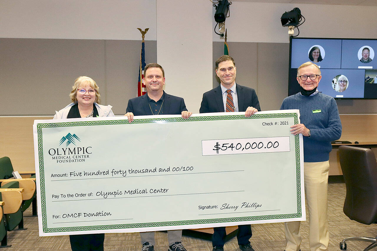 Holding a giant check of the $540,000 donation from the Olympic Medical Center Foundation to the hospital are, from left, OMC Executive Committee member Karen Rogers, OMC Commissioner Chair John Nutter, OMC CEO Darryl Wolfe, and Bruce Skinner, executive director of the foundation. (Dave Logan/For Peninsula Daily News)