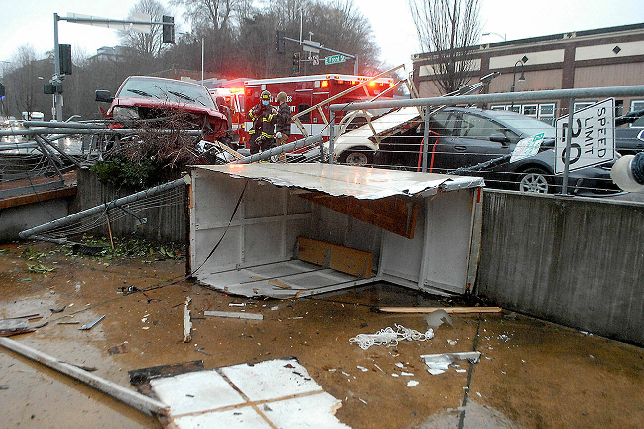 Keith Thorpe/Peninsula Daily News
Emergency workers investigate after a westbound pickup truck lost control, struck a parked trailer on East Front Street and veered into a railing during Saturday's farmers market at The Gateway transit center pavillion in downtown Port Angeles. Cpl. Erik Smith of Port Angeles police said the male driver apparently had a medical issue at the time of the wreck, but he and a juvenile passenger were uninjured. No market vendors were set up at the site of the site of the incudebt and no one at the market was injured. A parked car, a street sign and a light pole were also damaged.
