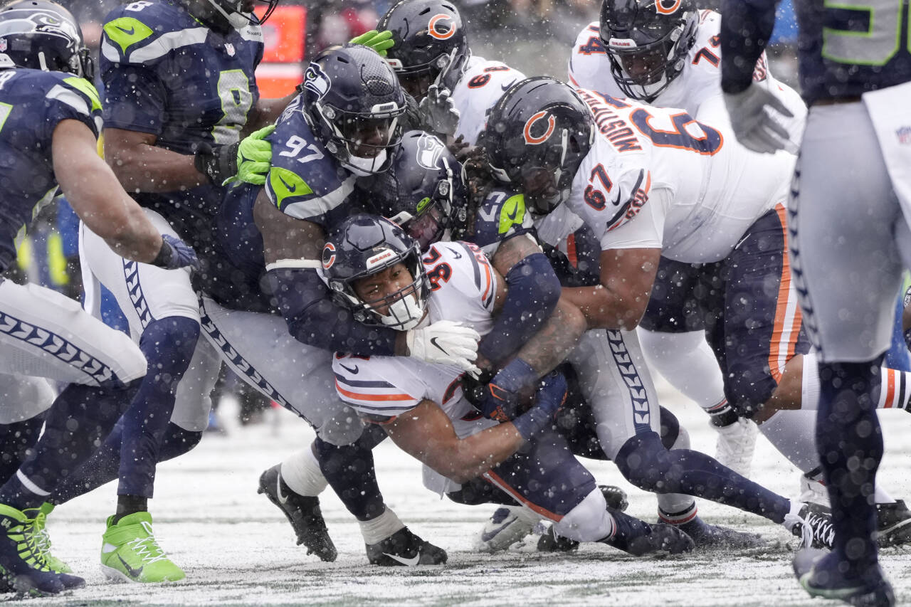 Chicago Bears running back David Montgomery, bottom, scores a touchdown on a carry against the Seattle Seahawks during the first half Sunday in snowy Seattle. (Stephen Brashear/The Associated Press)