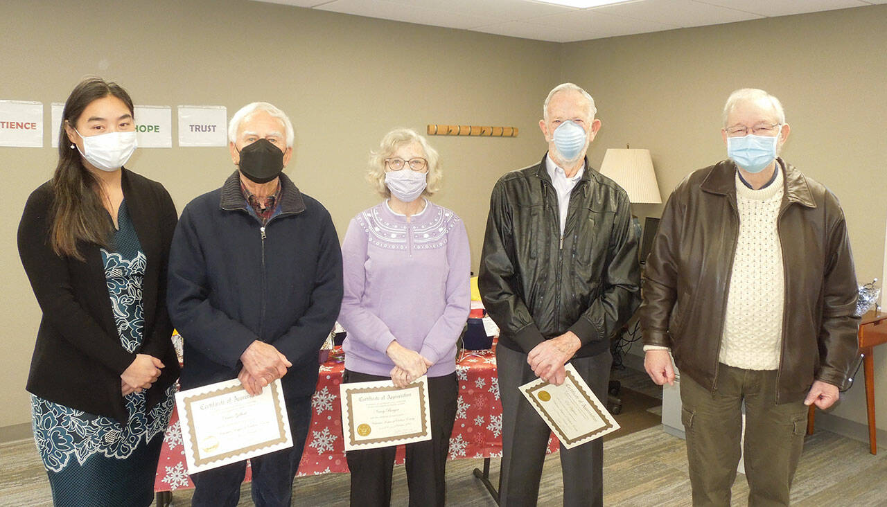 JooRi Jun, executive director for Volunteer Hospice of Clallam County, left, and board president Peter Raiswell, far right, honor outgoing board members Dave Gilbert, second from left, Nancy Bargar and Ed Hopfner. (Courtesy photo)