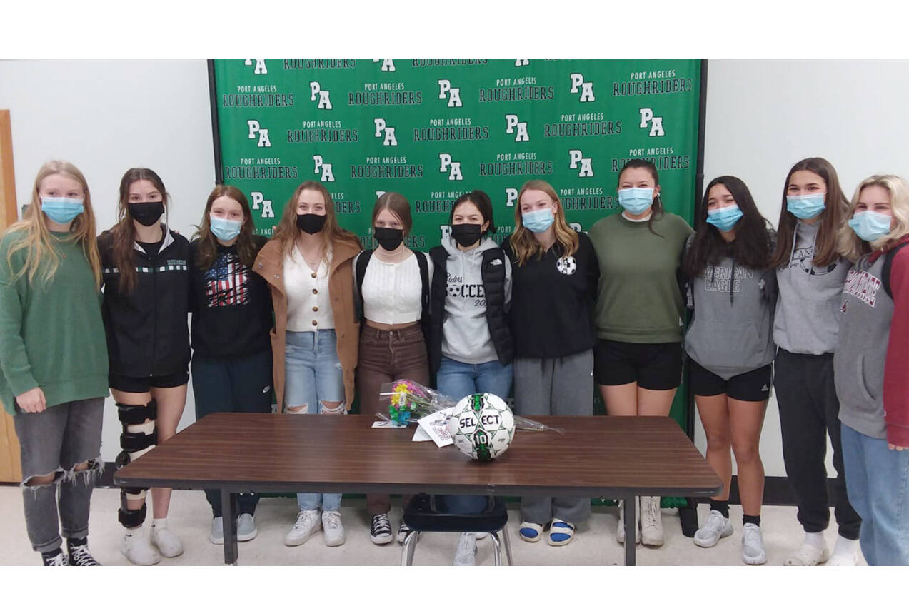 Mia Gagnon, center, midfielder for the Port Angeles Roughriders girls soccer team, is joined by her teammates while announcing her intent to play soccer for Bellevue College. (Pierre LaBossiere/Peninsula Daily News)