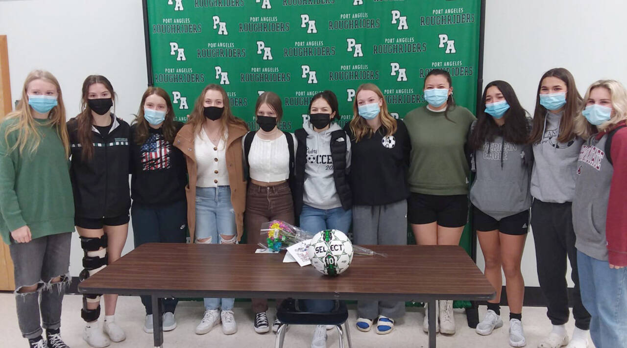Mia Gagnon, center, midfielder for the Port Angeles Roughriders girls soccer team, is joined by her teammates while announcing her intent to play soccer for Bellevue College. (Pierre LaBossiere/Peninsula Daily News)