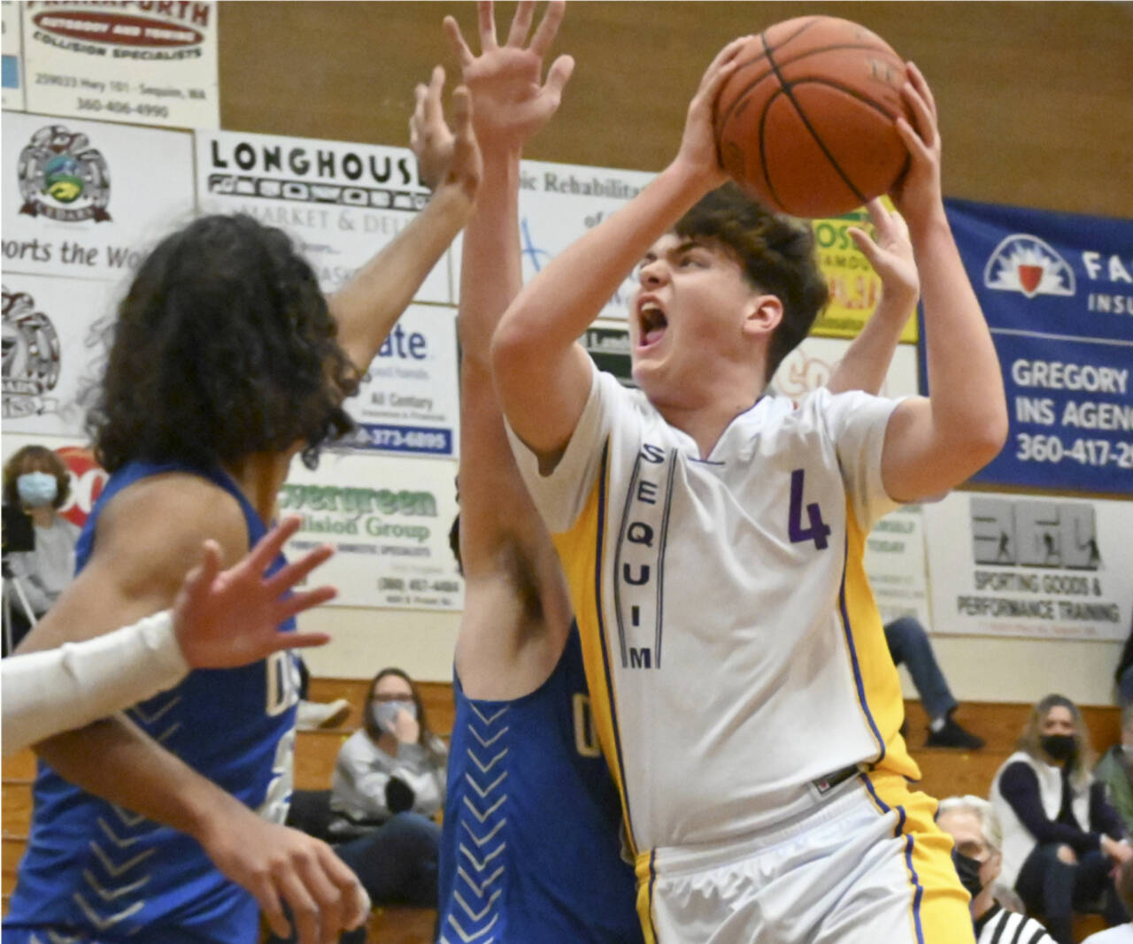 Sequim’s Keenen Green (4) drives the ball to the basket against Olympic on Monday night in Sequim. (Michael Dashiell/Olympic Peninsula News Group)