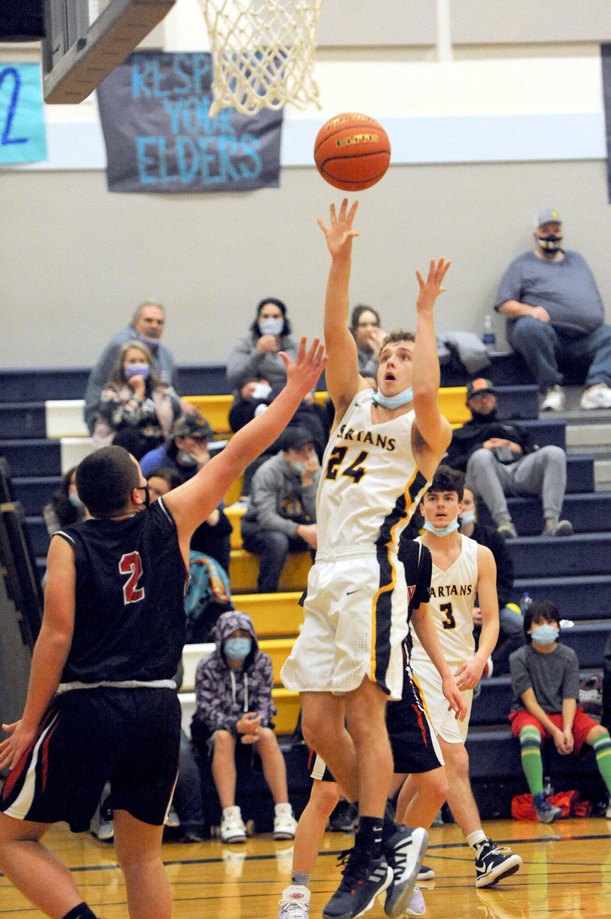 Forks’ Logan Olson scores over Neah Bay in a fast-paced contest in which the Spartans prevailed 62-54 over the Red Devils. (Lonnie Archibald/for Peninsula Daily News)