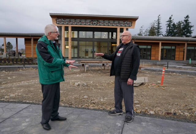 W. Ron Allen, right, chairman of the Jamestown S’Klallam Tribe, talks with Brent Simcosky, left, tribal health director, Wednesday, Feb. 2, 2022, in front of the Jamestown Healing Clinic, in Sequim, Wash. The tribe is building a full-service health center to treat both tribal members and other community residents for opioid addictions. Earlier in the week, Native American tribes across the U.S. settled a lawsuit against drug maker Johnson & Johnson and the largest three drug distribution companies in the U.S. for $590 million. The money won’t be distributed quickly, but tribal leaders say it will play a part in healing their communities from an epidemic that has disproportionately killed Native Americans. (AP Photo/Ted S. Warren)