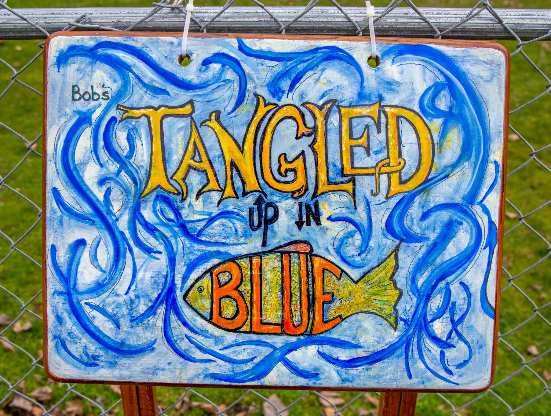 Suzanne Horne saved an unsteady TV tray from the landfill by painting it to hang at Carrie Blake City Park as part of the reuse/repurpose/recycle them of “Art All Over — The Art Show Without Walls,” sponsored by Sequim City’s Art Commission. (Emily Matthiessen/Olympic Peninsula News Group)