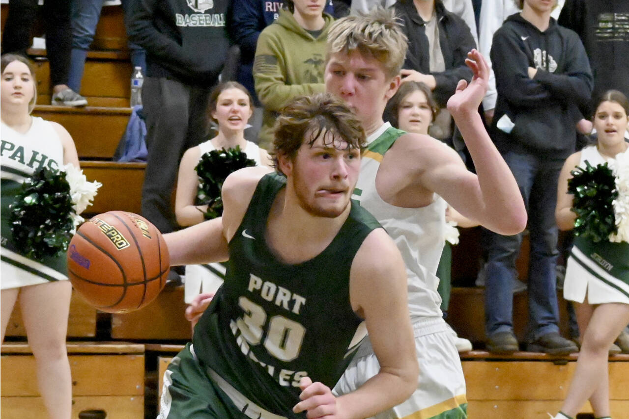 Port Angeles' Wyatt Dunning drives around the defense of Lynden's Kobe Baar in the 2A regionals held Friday night in Mount Vernon. (Michael Dashiell/Olympic Peninsula News Group)
