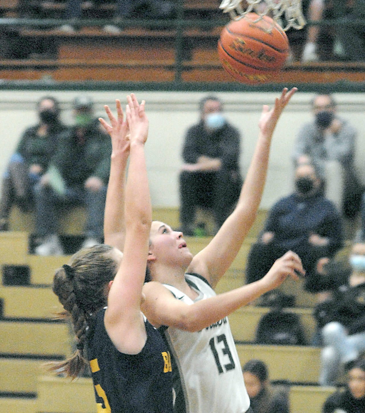 Port Angeles’ Bailee Larson, right, scores on a layup against Bainbridge in Port Angeles in December. Larson is one of the Roughriders’ top players and passers. (Keith Thorpe/Peninsula Daily News)