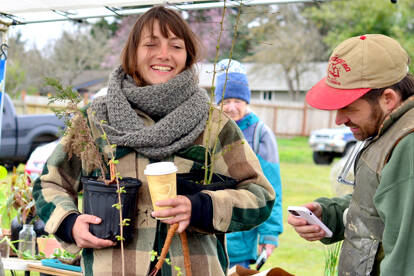 Plant and Seed Exchange Organizer Ashley Kehl, left in hat, mingles with visitors including Bryan DeCaterina of Port Townsend, at right, and Daryl Dietrich of Quilcene on Sunday at Shy Acre Farm during the annual event in Port Townsend. Held on the first day of spring, there was a chilly breeze and a good turnout. (Diane Urbani de la Paz/Peninsula Daily News)