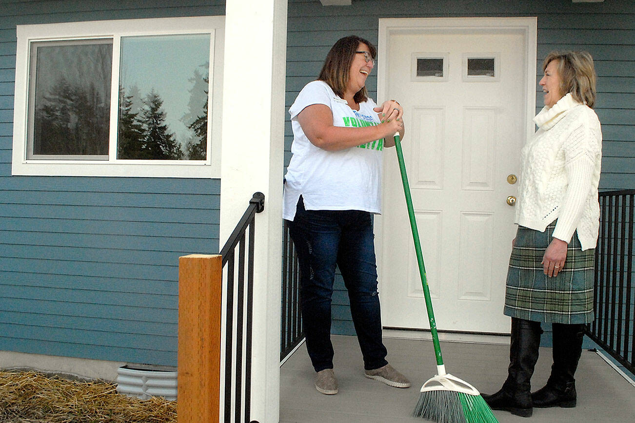 Keith Thorpe/Peninsula Daily News
Habitat for Humanity of Clallam County CEO Colleen Robinson, left, talks with Julie Maron, the organization's family resource manager, on the porch of a completed Habitat house on Maloney Court in Port Angeles on Thursday.