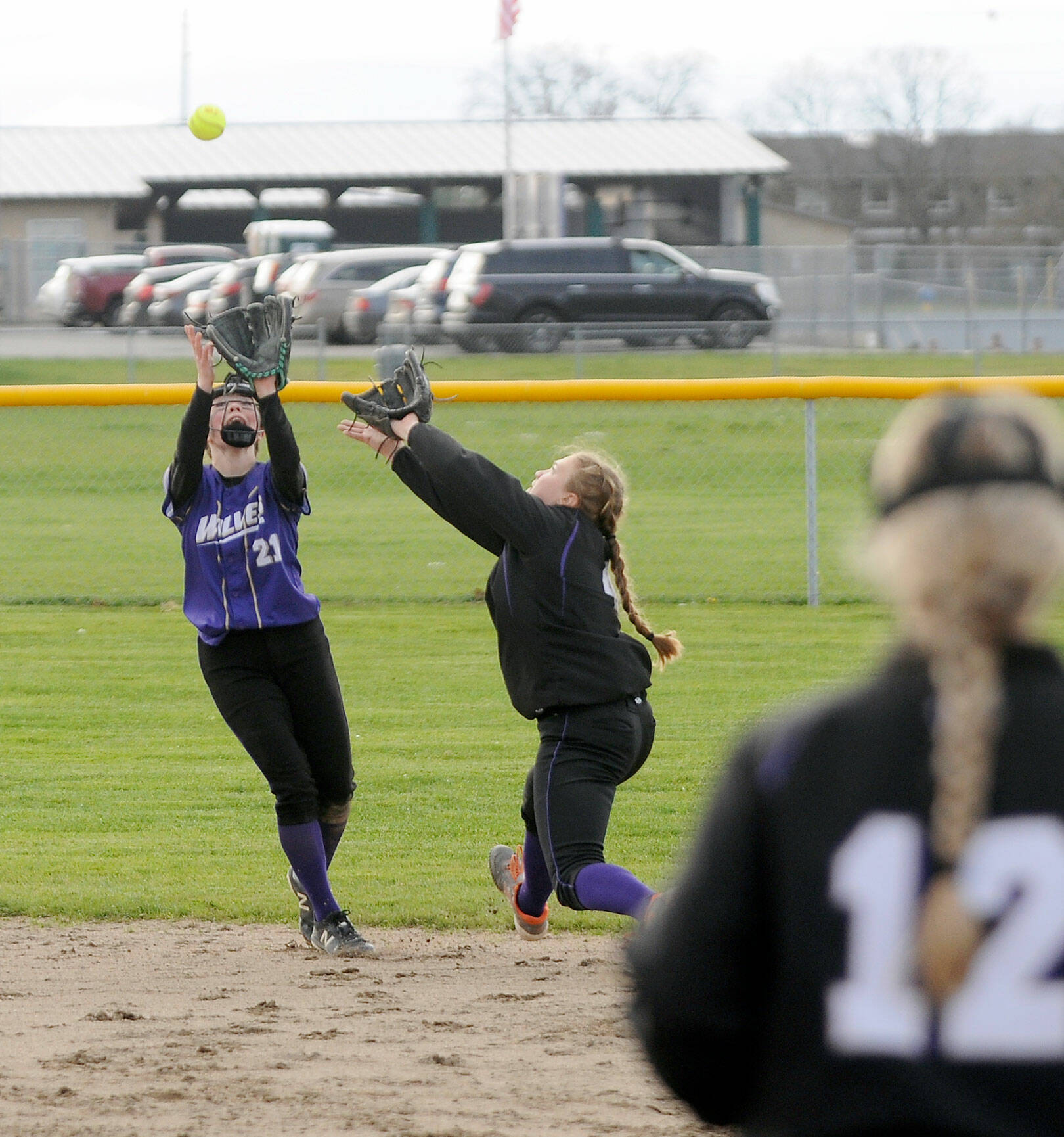 Sequim shortstop Hannah Bates, left, and second baseman Addie Smith converge on an infield fly ball during the Wolves’ 8-6 loss to North Kitsap on Tuesday. (Michael Dashiell/Olympic Peninsula News Group)