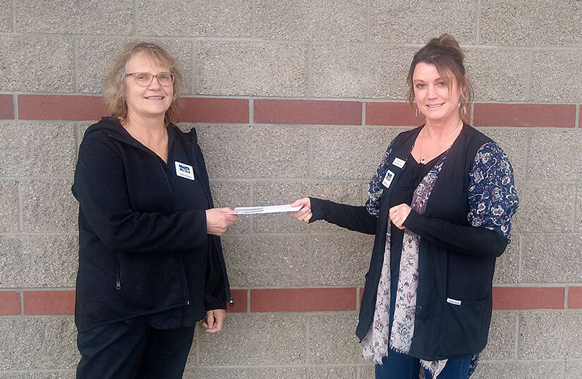 Heidi Albrecht, left, treasurer for Coats for Kids, receives a check from Cheryl Stipe of Jim’s Pharmacy.