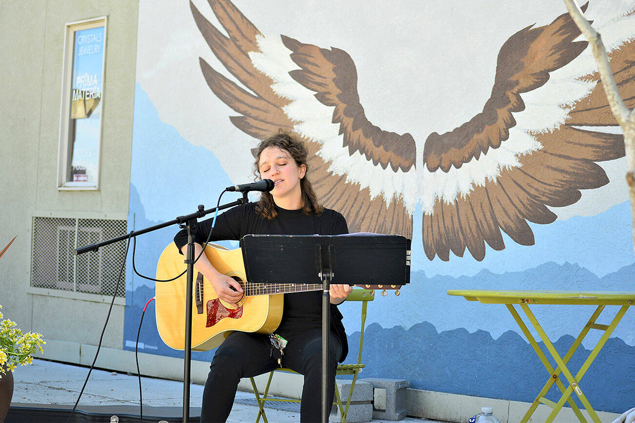Phina Pipia of Port Townsend, pictured in spring 2021, is one of the multi-instrumentalists returning to the Buskers on the Block series of free performances this month and next. Tyler Street Plaza in downtown Port Townsend, with Nora Kingsley’s wings mural, is the setting. (Diane Urbani de la Paz/Peninsula Daily News)