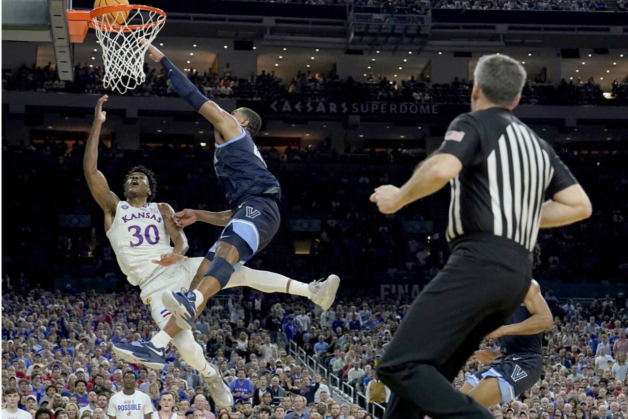Kansas guard Ochai Agbaji (30) shoots as Villanova forward Eric Dixon defends during the second half of a college basketball game in the semifinal round of the Men's Final Four NCAA tournament, Saturday, April 2, 2022, in New Orleans. (AP Photo/Brynn Anderson)