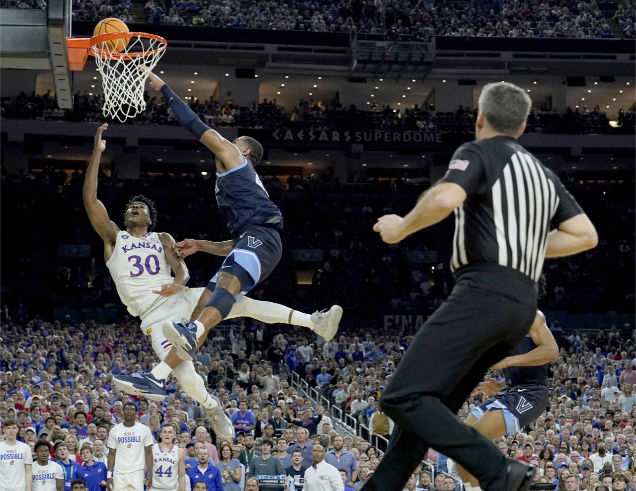 Kansas guard Ochai Agbaji (30) shoots as Villanova forward Eric Dixon defends in the semifinal round of the Men’s Final Four NCAA tournament Saturday in New Orleans. (Brynn Anderson/The Associated Press)
