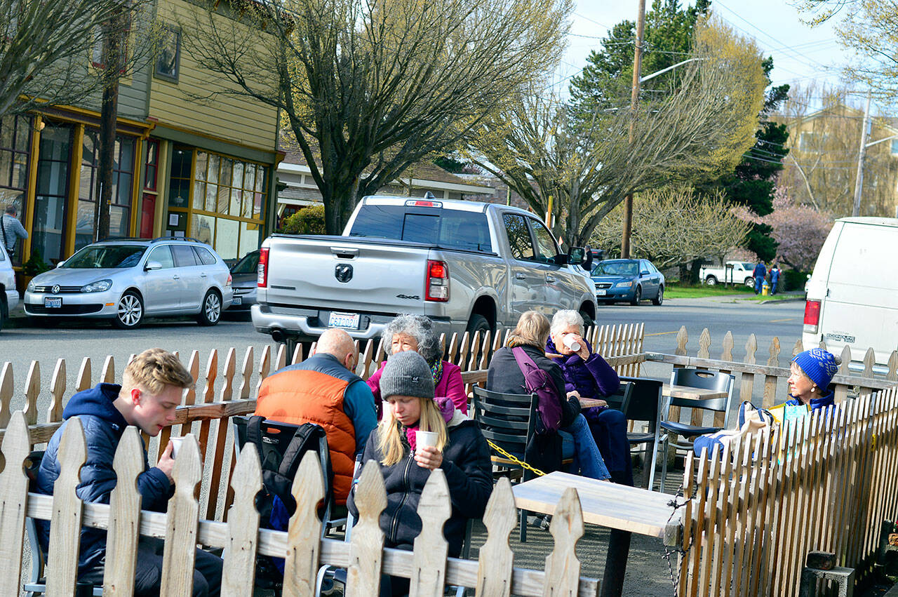 Vehicles pass a streatery on Lawrence Street, where patrons of Seal Dog Coffee stopped in Saturday morning. (Diane Urbani de la Paz/Peninsula Daily News)