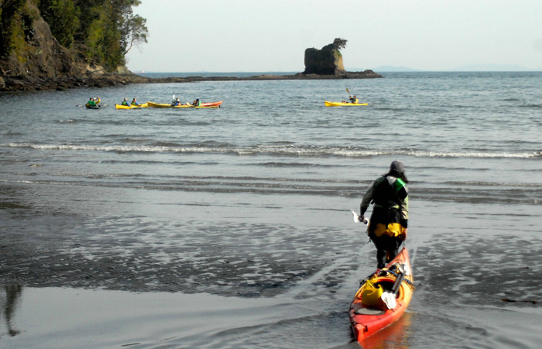 Nina Sarmiento, a sea kayak guide with Adventures Through Kayaking, pulls out to lead a group of kayakers in the waters of Freshwater Bay west of Port Angeles on Thursday. The group was paddling out to explore the area around the Bachelor Rock sea stack, accessible by water from Freshwater Bay County Park. (Keith Thorpe/Peninsula Daily News)