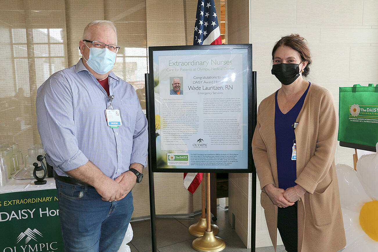 Emergency department nurse Wade Lauritzen, left, receives a DAISY award from Vickie Swanson, Olympic Medical Center's chief nursing officer.
