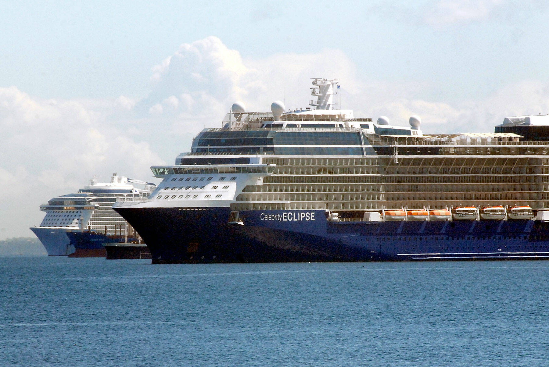 Keith Thorpe/Peninsula Daily News
The cruise ships Celebrity Eclipse, front, and Ovation of the Seas, rear, sit anchored in Port Angeles Harbor on Friday as they await the Alaskan cruise season. Both ships are operated by the Royal Caribbean Group or its subsidiaries. Anchored between the cruise vessels are the bulk carrier James Bay and the pusher tug Dublin Sea.