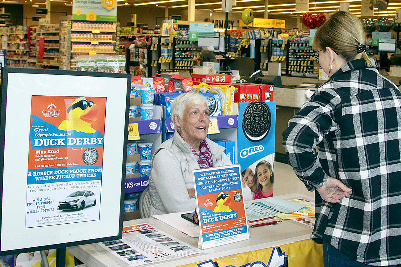 Marielle Eykeman, a volunteer, sells a Duck Derby ticket to Vonda Hartman at the downtown Safeway earlier this week. This year’s Duck Derby will be on the Port Angeles waterfront. (Dave Logan/for Peninsula Daily News)