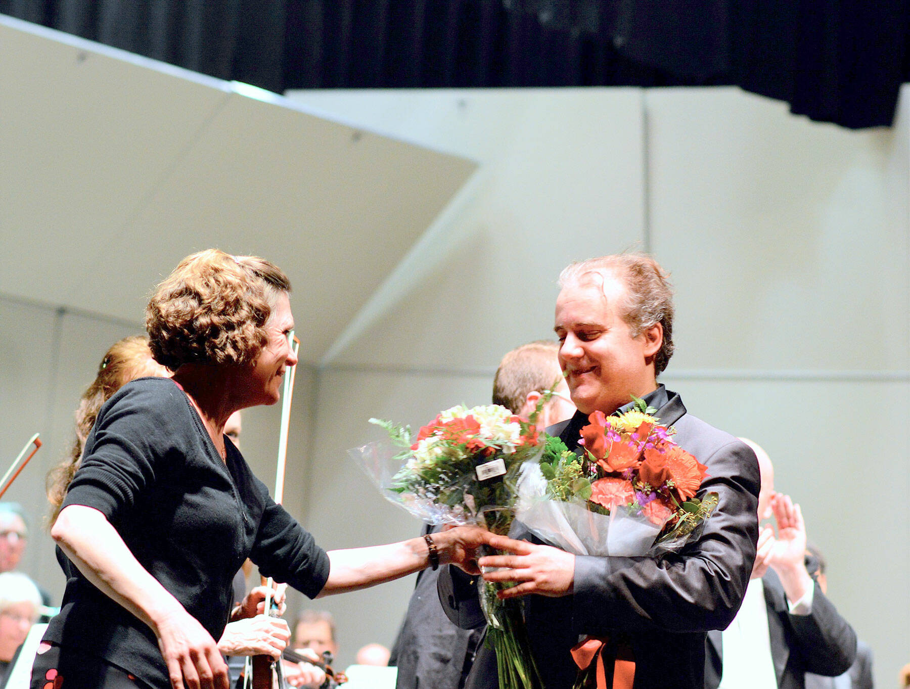 Piano soloist Josu De Solaun, pictured in February 2020 receiving flowers from Port Angeles Symphony volunteer Dorthe Grube Porter, will return as one of the guest artists in the orchestra’s 90th anniversary season. Tickets for the 2022-2023 series of 13 concerts will go on sale this summer. (Diane Urbani de la Paz/Peninsula Daily News)