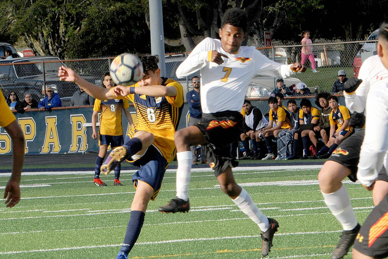 Forks’ Arturo Dominguez-Gomez, left, kicks past Winlock’s Xavier Sancho at Spartan Stadium. Forks won 5-4. (Lonnie Archibald/for Peninsula Daily News)